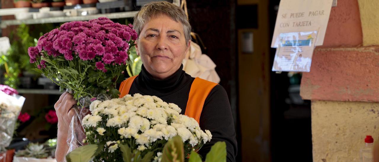 Azucena Suárez,  posando para LA NUEVA ESPAÑA, este domingo, entre las flores de su puesto en el mercado del Fontán, en Oviedo. | Irma Collín