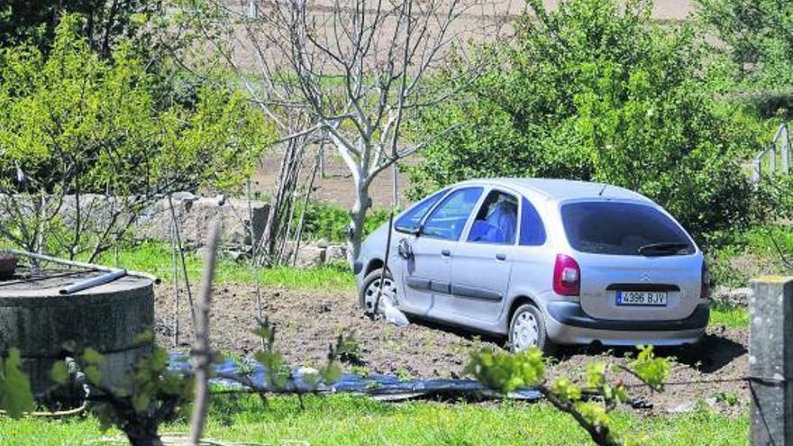 El vehículo en el que huyeron los delincuentes, abandonado tras quedar atascado en una finca. En el recuadro superior izquierdo, la imagen del hombre perseguido.  // Noé Parga