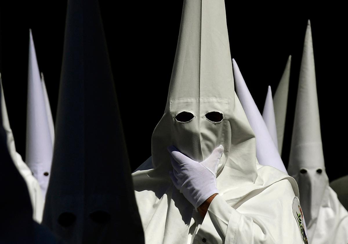 Penitentes de la hermandad de La Paz participan en la procesión del Domingo de Ramos en Sevilla