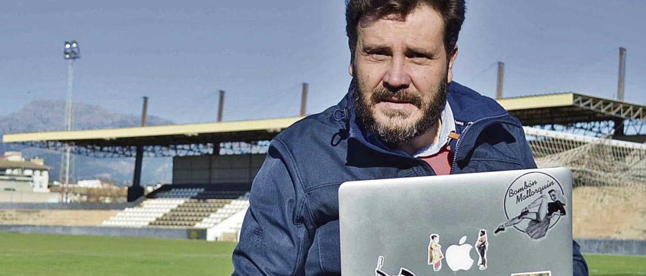 Miguel Ángel Cortés posa, con su inseparable ordenador, en el terreno de juego del Nou Camp de Inca.