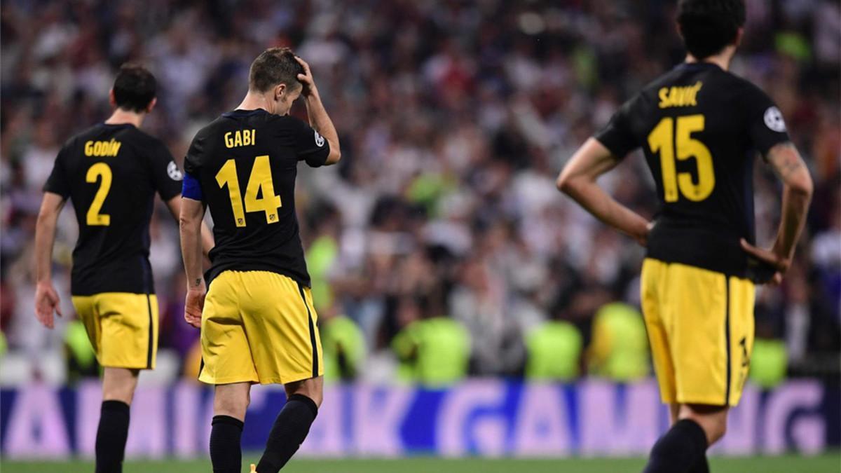 Los jugadores del Atlético, tras recibir el tercer gol del Real Madrid