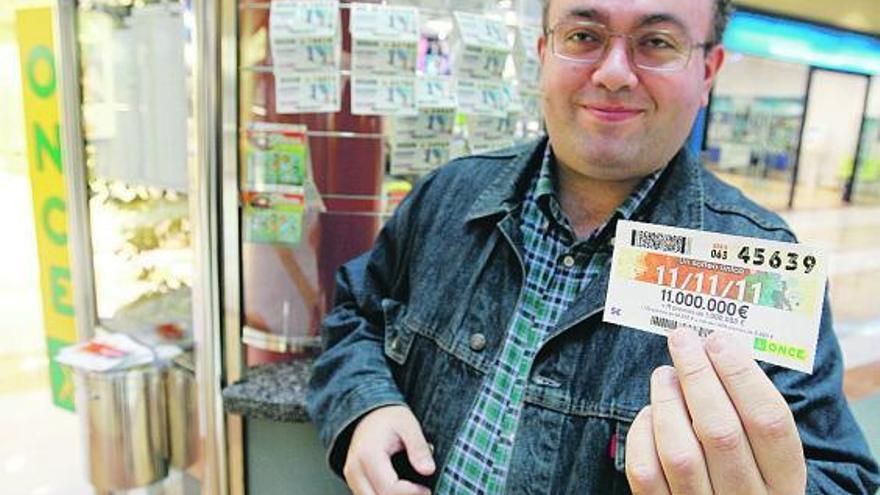 El vendedor de la Once Javier Fernández Alas muestra un cupón del sorteo del 11-11-11. | luisma murias