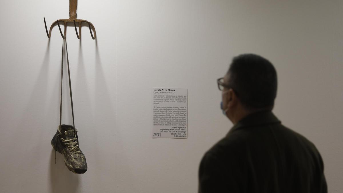 Un visitante observa una escultura en la exposición "Expoperegrina 2021", en Trascorrales.