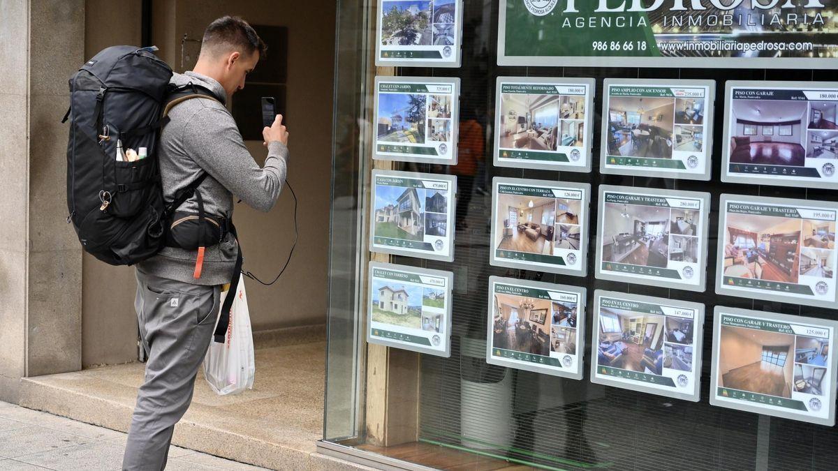 Un joven fotografía pisos en una agencia inmobiliaria de Pontevedra.
