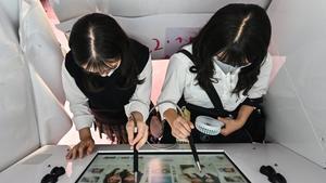 Dos chicas se toman fotos en una máquina de ’purikura’, en Tokio, a finales de julio.