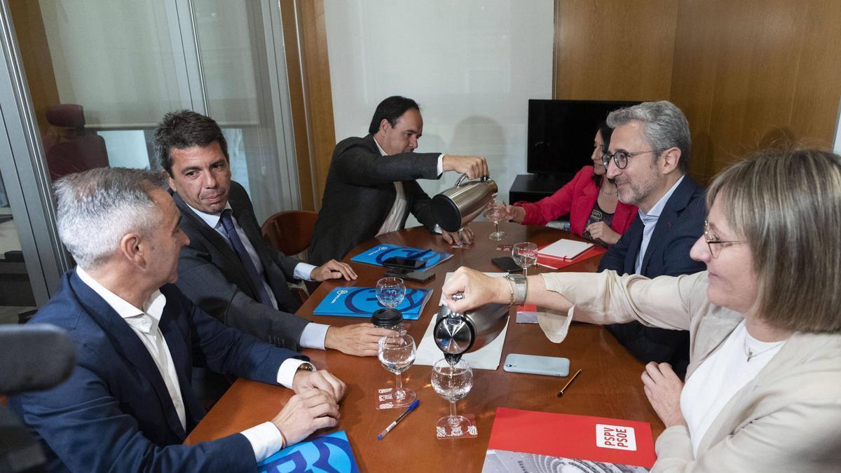 Llorca, con la jarra, y, al otro lado de la mesa, Arcadi España, cuando no eran president y ministro: en la reunión en 2023 para formar Consell. para