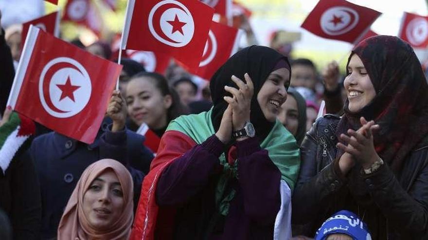 Mujeres ondean banderas tunecinas en el aniversario de la revuelta. // Efe