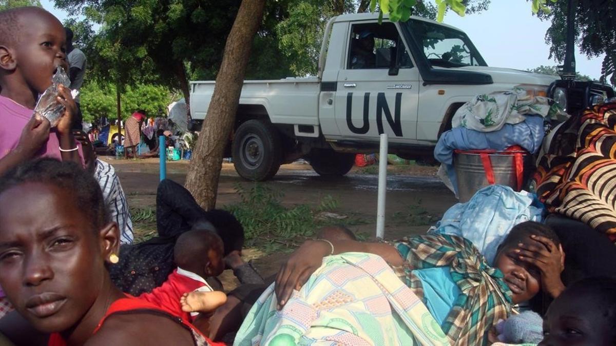 Un vehículo de la ONU junto a familias desplazadas de Sudán del Sur, en la misión de las Naciones Unidas en Tomping (Yuba), el 11 de julio del 2016.