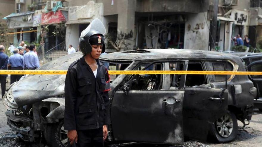 Un policía egipcio, junto a un coche afectado por la explosión del coche-bomba.