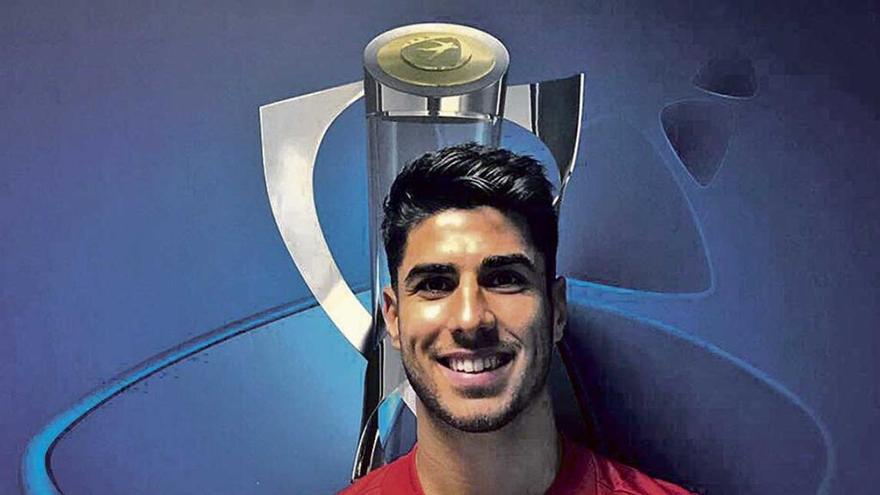 Marco Asensio posa con el balón firmado por sus compañeros.