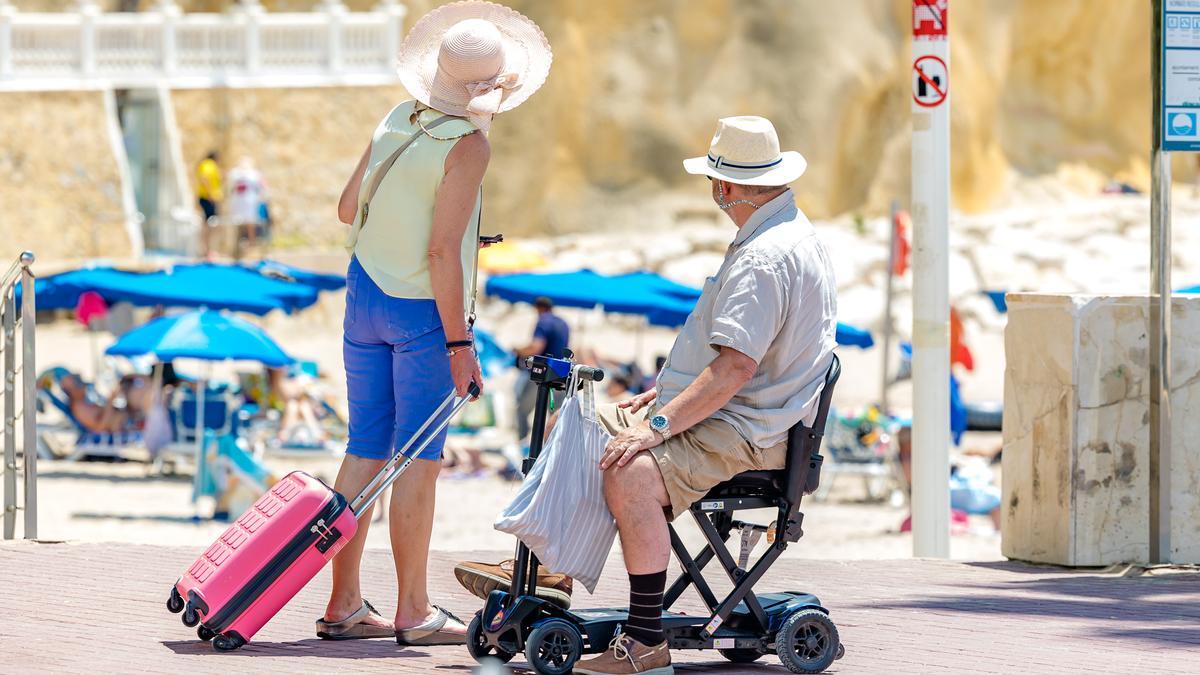 Turistas acceder a una  de las playas de Benidorm.