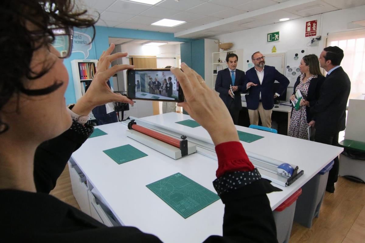 Uno de los jóvenes fotografía con su móvil al consejero Nieto y a los responsables del centro durante la visita.