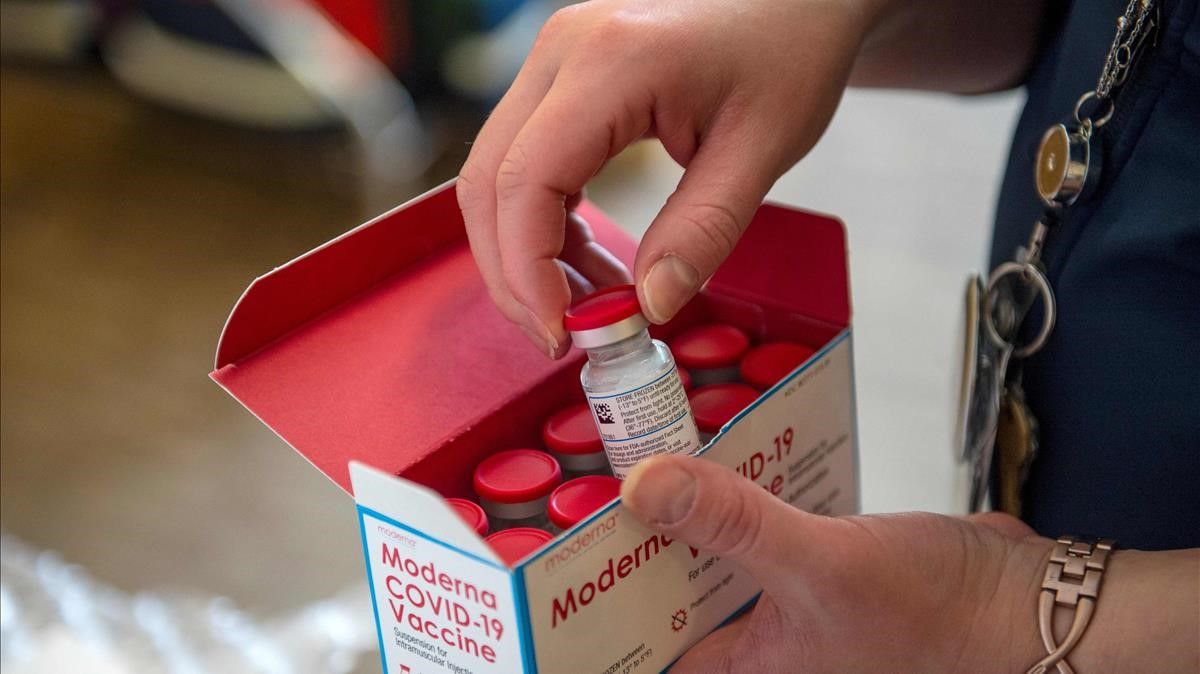 Una mujer abre una caja con vacunas contra el covid de Moderna en la localidad estadounidense de Boston, el pasado 24 de diciembre