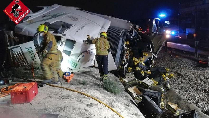 Los bomberos examinando el tráiler tras rescatar al conductor.