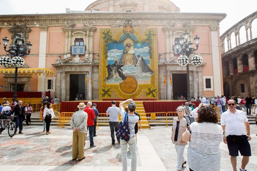 Numerosas personas acuden a la plaza de la Virgen de València para contemplar el tapiz floral