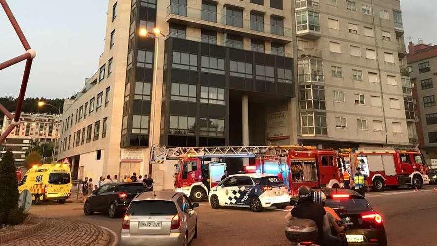 Los bomberos y la policía durante las labores de extinción del incendio, ayer, en el edificio de Vigo. // Nick