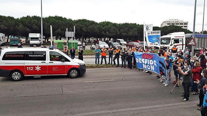 Trabajadores de Ebhisa, concentrados en el acceso a El Musel por El Arbeyal, aplaudiendo a la ambulancia que traslada a uno de los huelguistas.