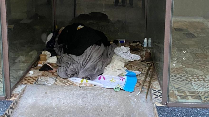 Una persona duerme en un portal de Gandia