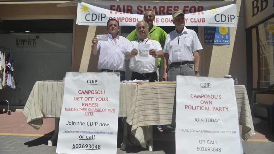 Miembros de la candidtura de CDiP, con su cabeza de lista en el centro de la imagen, posan en una mesa de campaña en Camposol.