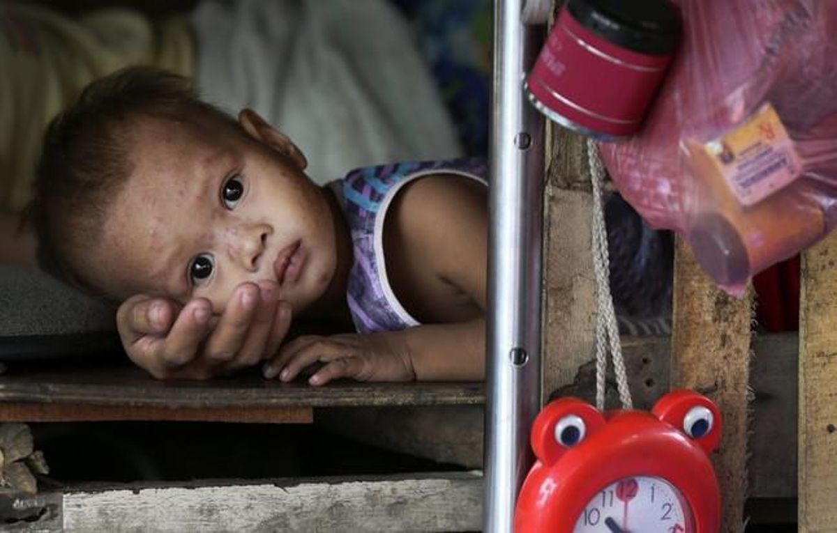 Una dona i el seu fill descansen dins de la seva barraca mentre esperen a ser evacuats d’una barriada pobra del districte de Baseco, Manila.