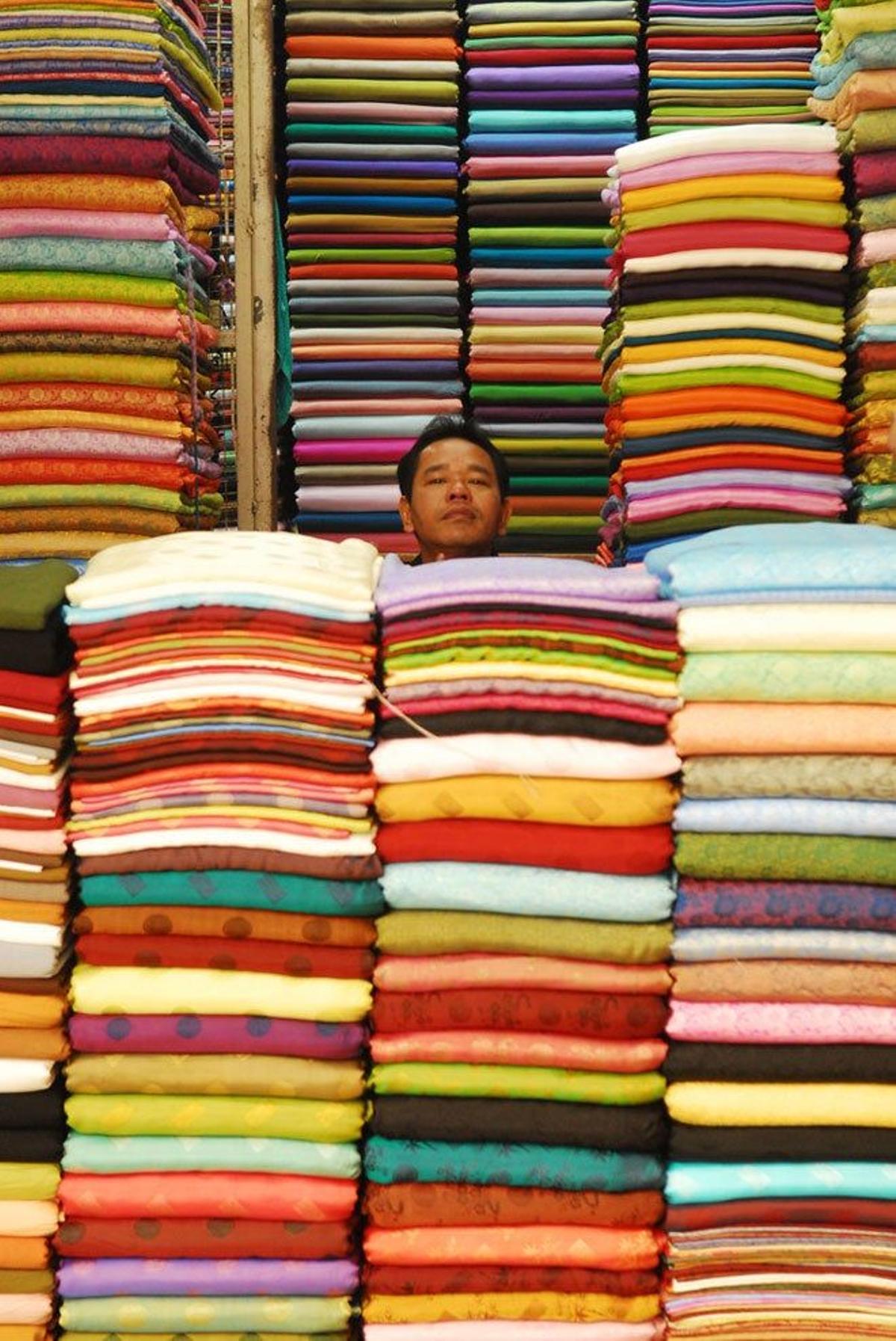Vendedor en su puesto de tejidos en Hanoi.