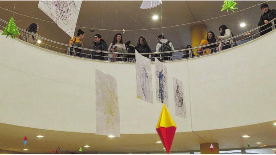 Alumnos de la Escuela Universitaria de Magisterio observan una exposición sobre Baltasar Lobo en el hall del centro. |