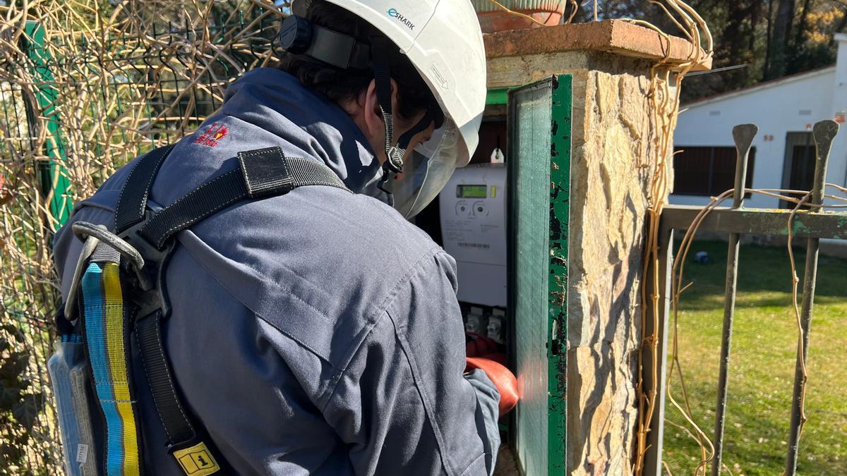 Un operari d'Endesa comprova si un comptador està manipulat en una urbanització de Llagostera