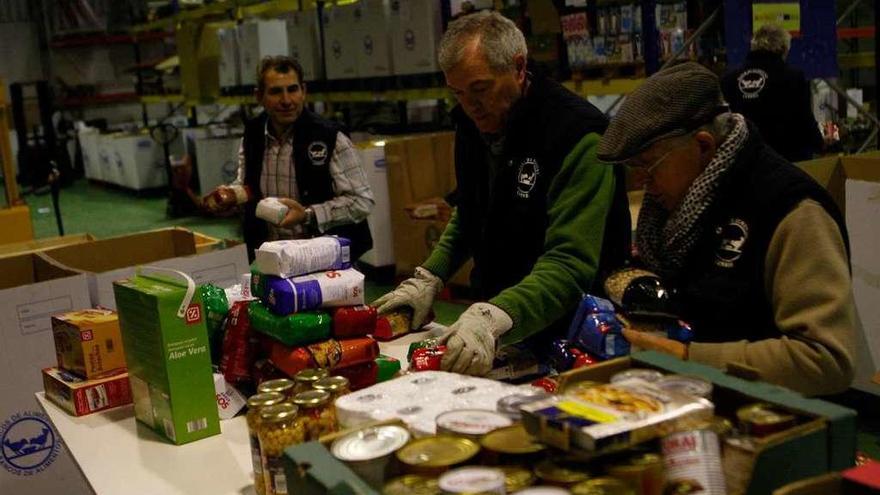 Voluntarios del Banco de Alimentos organizan en su almacén los productos recogidos.
