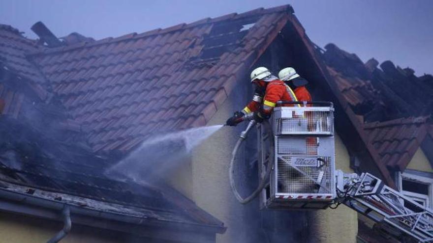 Bomberos alemanes enfrían la casa incendiada en la que fallecieron 8 personas. // Reuters