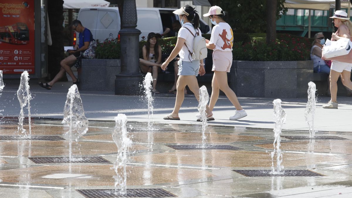 Varias personas pasean junto a una fuente del centro de Córdoba.