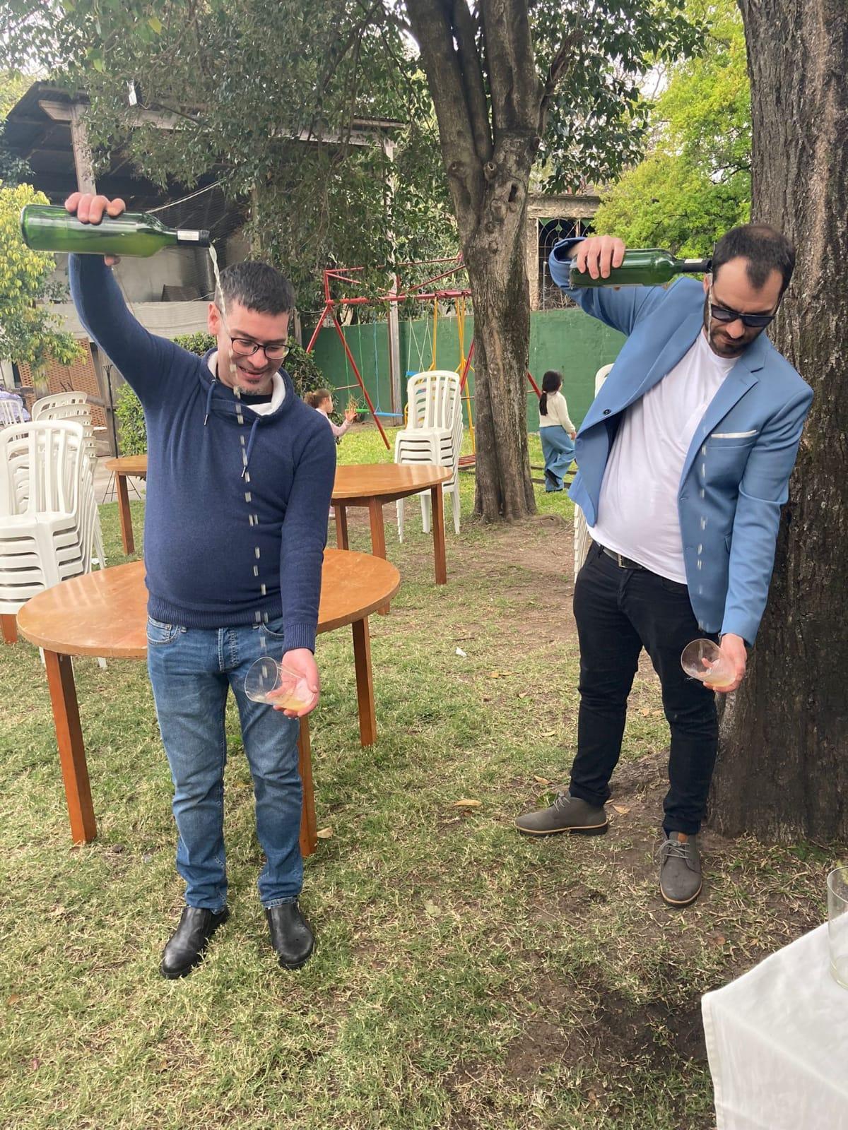 Luis Manuel Bousoño, a la izquierda, y Andrés González, escanciando sidra elaborada en el Centro Asturiano de Montevideo.