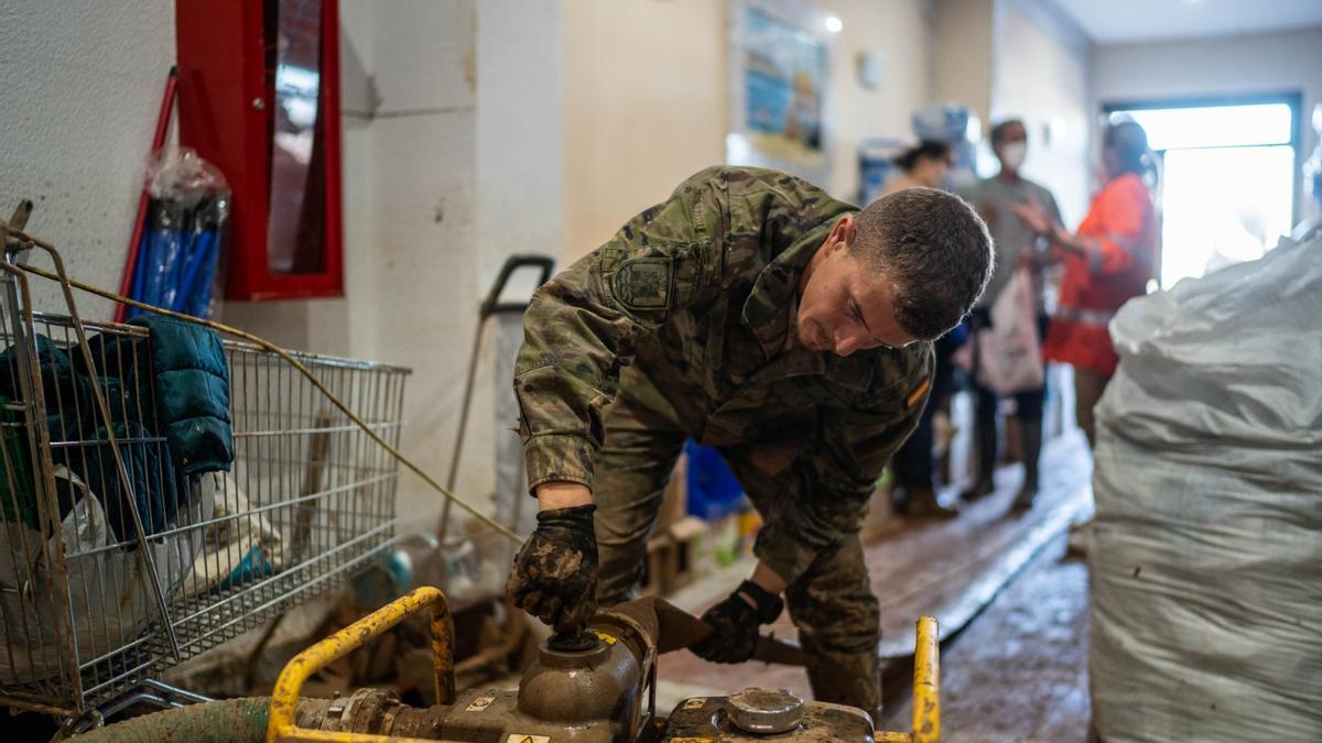 Un militar realiza tareas de limpieza, este domingo en Massanassa