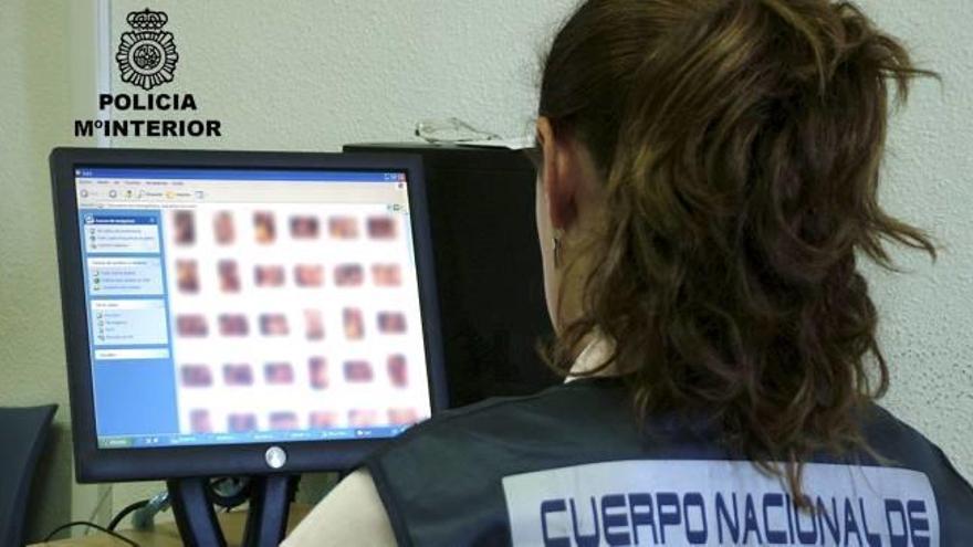 Una policía examina material intervenido contra una red de distribución de pornografía infantil.