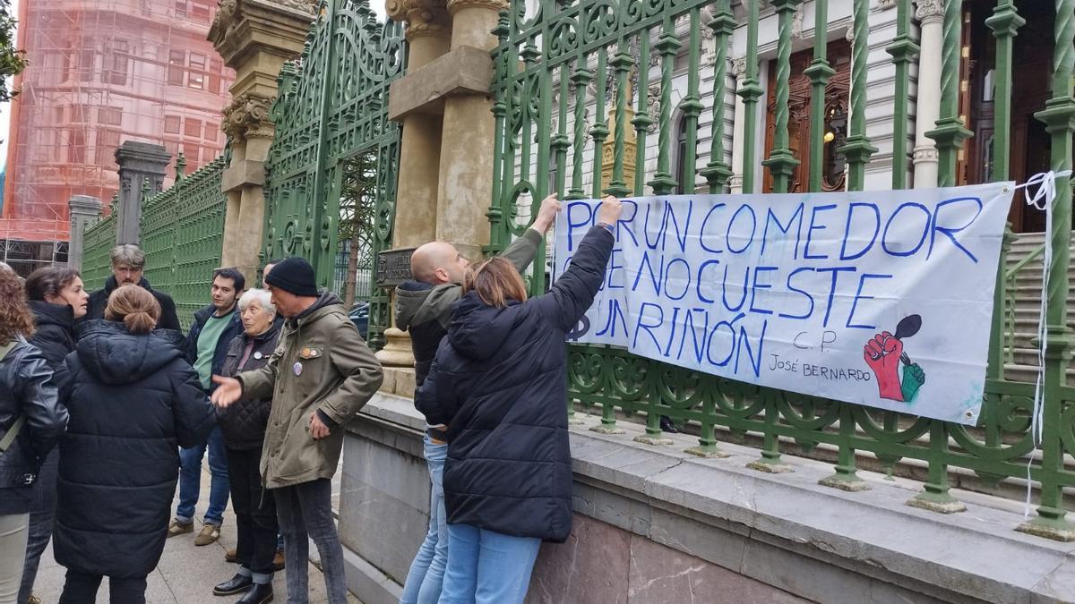 Los padres, colocando una pancarta en la Junta General del Principado