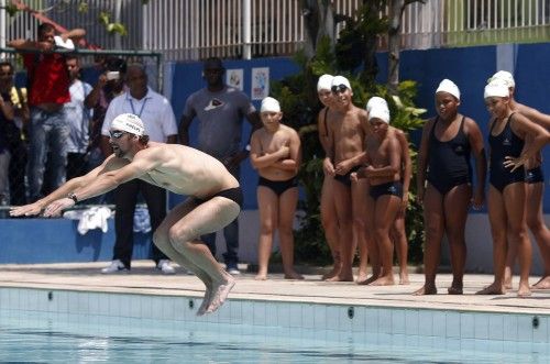 U.S. Olympic swimmer Michael Phelps gives a swimming lesson to youths during a visit at the Alemao slum complex's Olympic Village in Rio de Janeiro