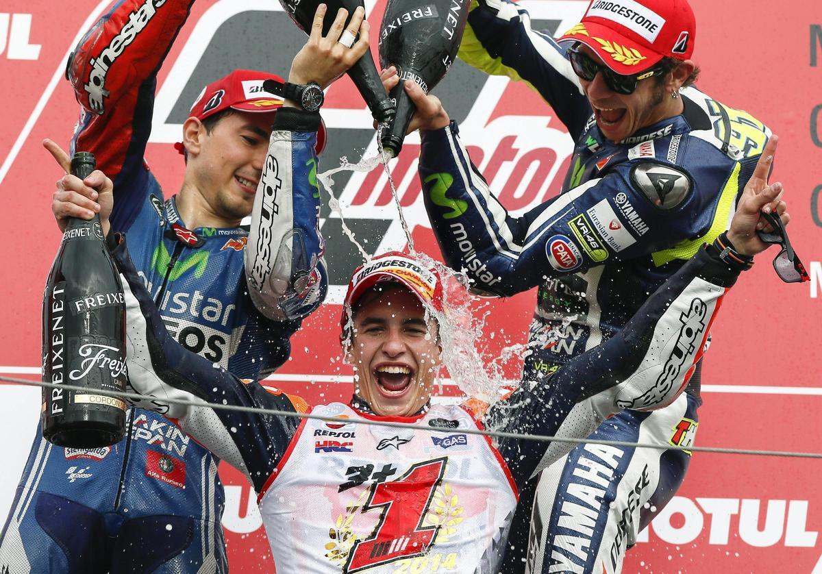 Jorge Lorenzo y Valentino Rossi rocía con champán a Marc Márquez en 2014.