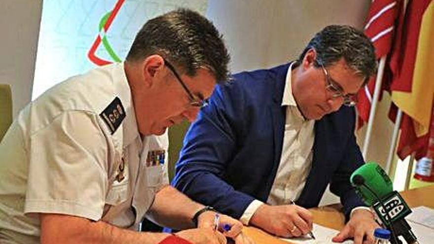 El comisario provincial de la Policía y el presidente del colegio de farmacéuticos, durante la firma .