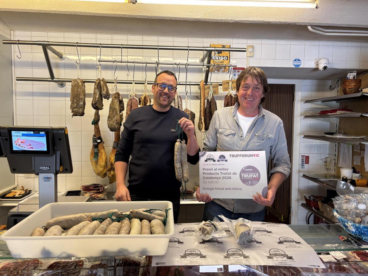 Els germans Joan i Carles Prat a la carnisseria mostrant el donegal que els ha donat el premi