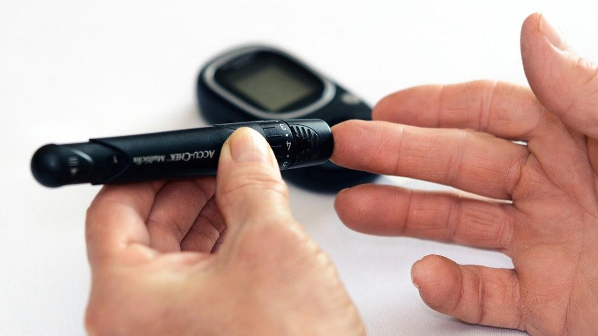 Un hombre se pincha en el dedo para medirse la glucosa en sangre.