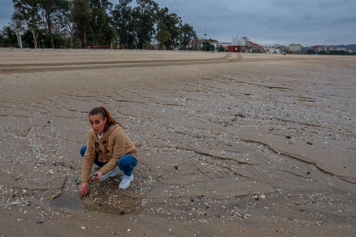 Una mariscadora mostrando almeja muerta en la playa de Vilagarcía.