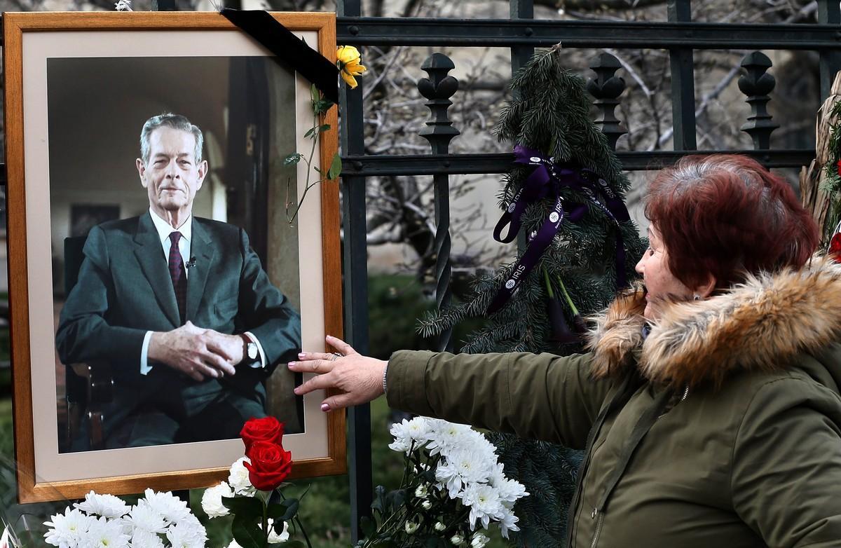 Una ciudadana rumana toca un retrato del rey Miguel I de Rumanía, frente al Palacio Real en Bucarest.