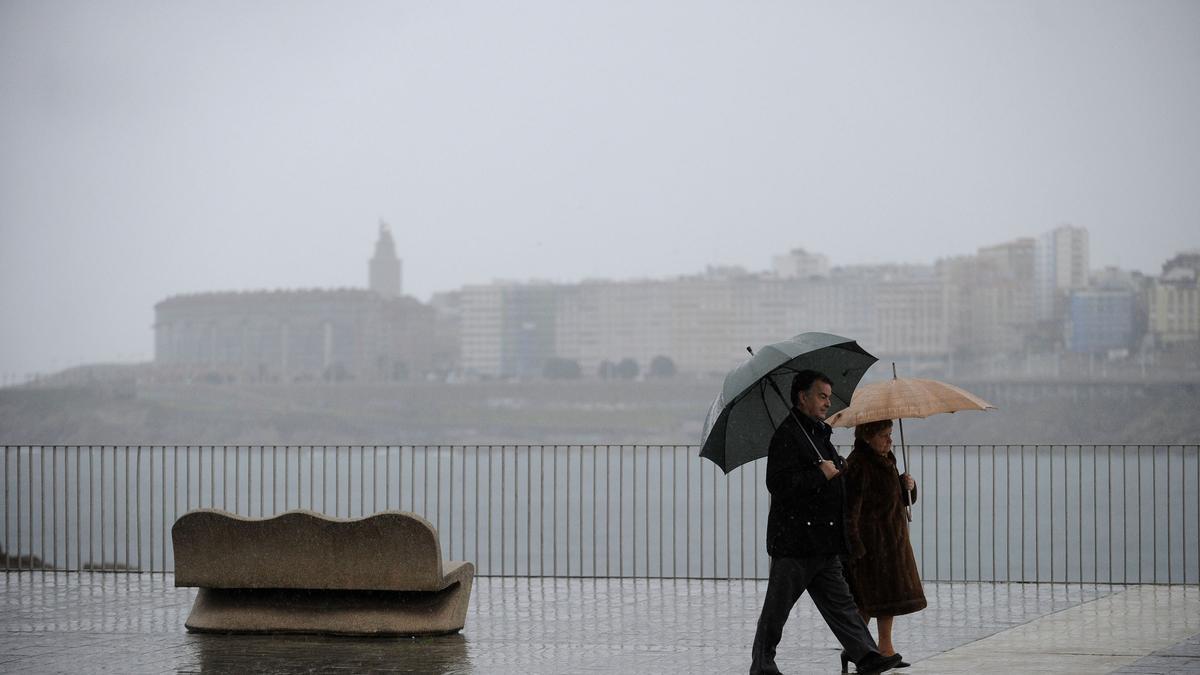 Dos personas en un día lluvioso por el paseo marítimo de A Coruña