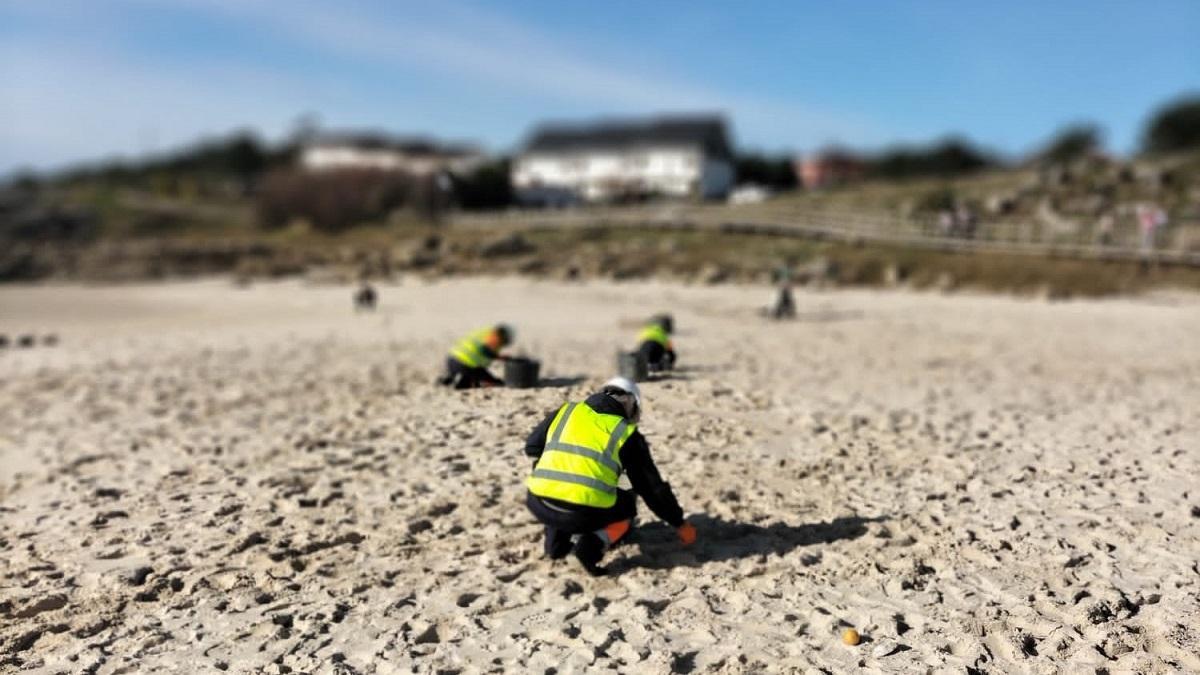 Técnicos de la Xunta retirando microbolas plásticas en una playa