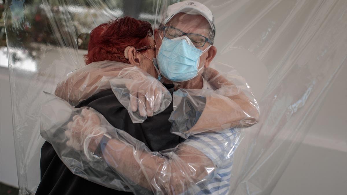 Una mujer interna en una residencia de mayores de València abraza a su sobrino a través de un plástico habilitado a tal efecto, el 17 de junio pasado