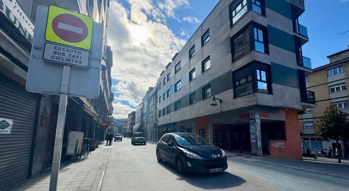 La calle Libertad, en Pola de Laviana, este sábado, con el tráfico circulando en dirección Barredos. | D. O.