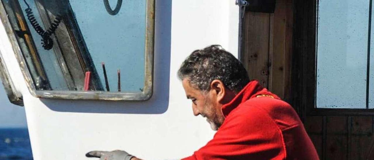 Un pescador arousano sostiene un pulpo recién capturado. // Iñaki Abella