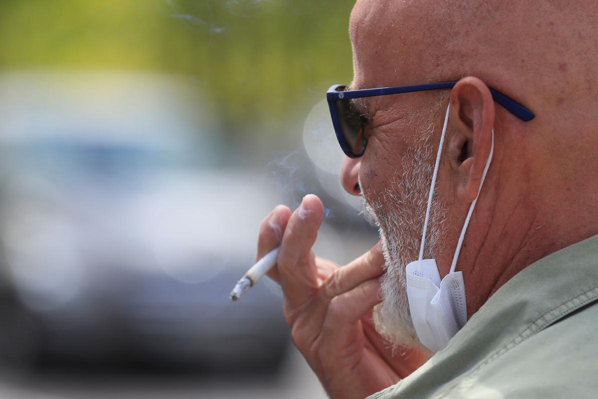 Un hombre mayor se fuma un cigarro