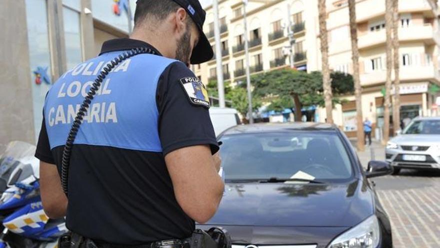 Un agente de la Policía Local de Santa Cruz de Tenerife multa a un coche.