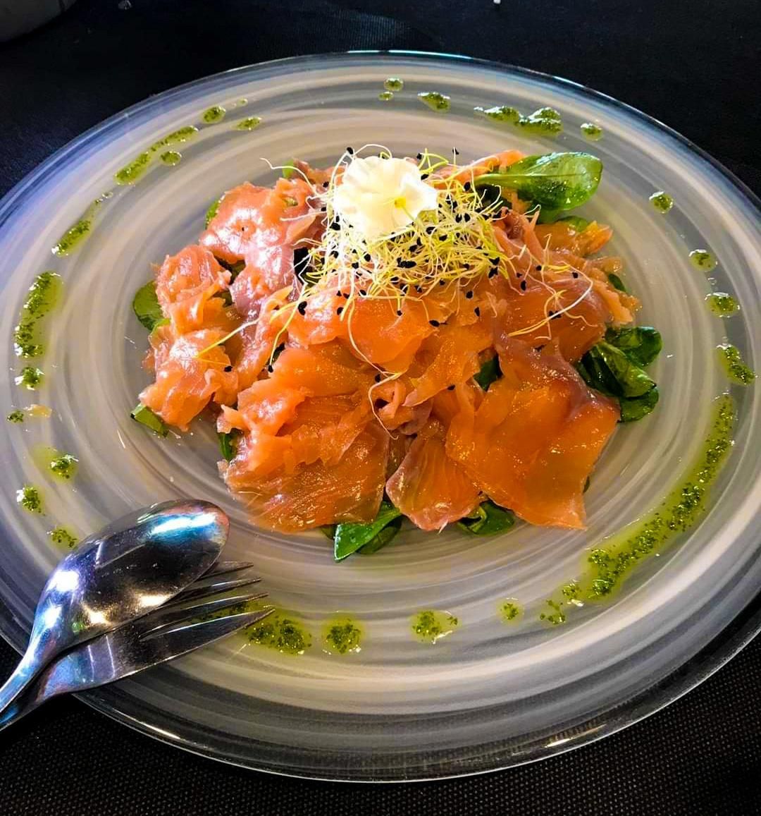 Salmón marinado sobre brotes tiernos y aceite de cítricos.