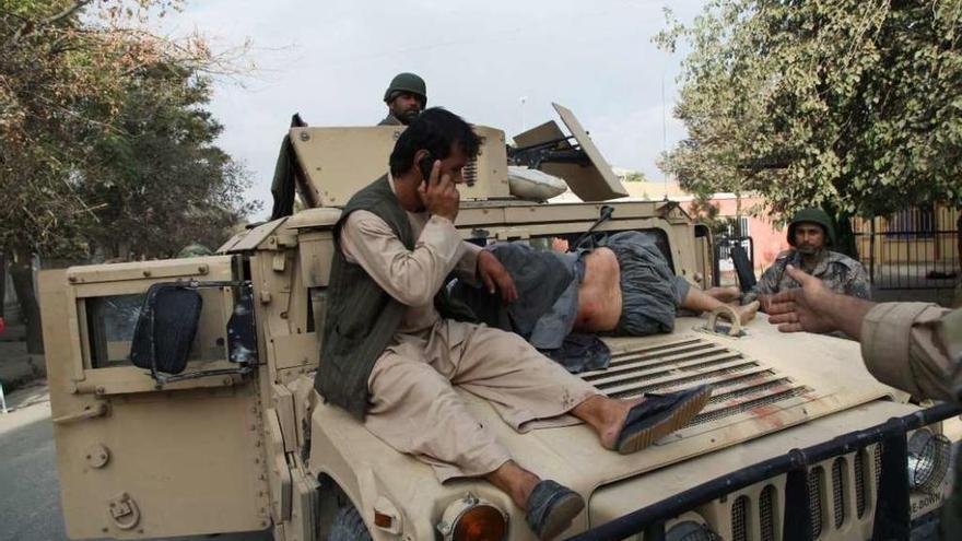 Soldados afganos, con un herido, camino del hospital de Kunduz. // Reuters